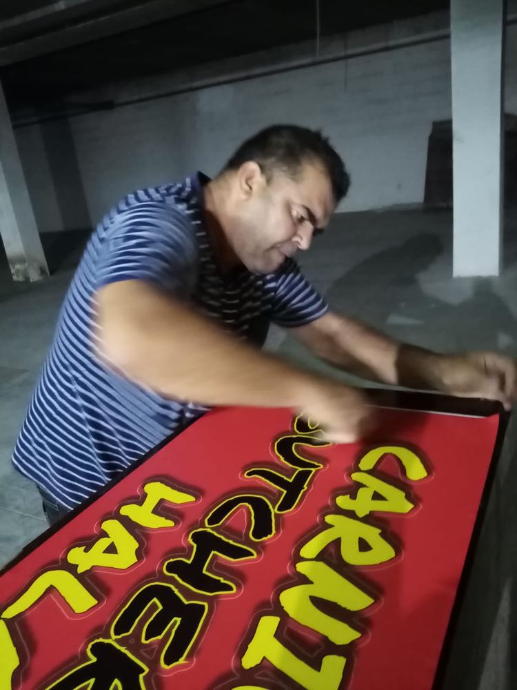Montando el rótulo de la carnicería Los Abrigos